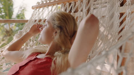 young woman in hammock enjoying comfortable lifestyle on vacation in holiday resort swaying peacefully on lazy summer day in tropical paradise cabin