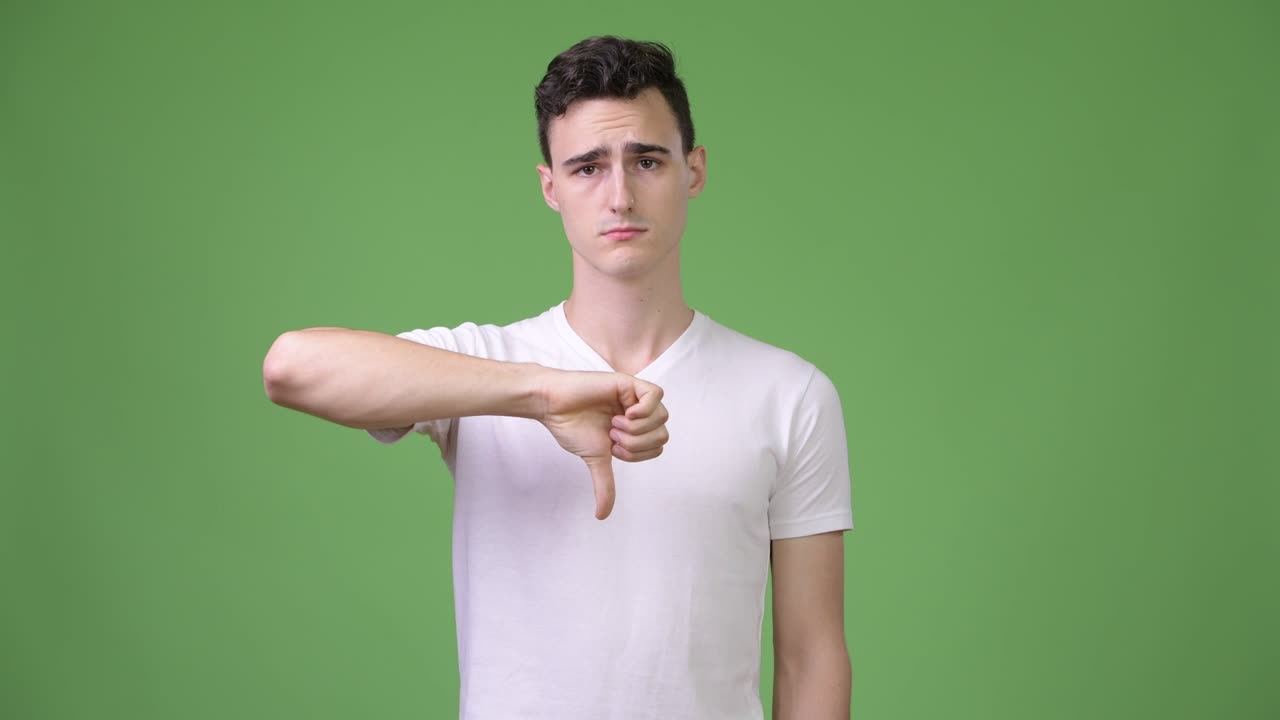 아래로 엄지 손가락을주는 젊은 잘 생긴 남자