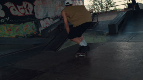 active teenager in sneakers riding on skate board in modern urban skate park.