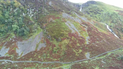 Idyllic-Snowdonia-mountain-range-Aber-falls-waterfalls-national-park-aerial-left-pan-across-moorland-view