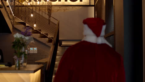 strong santa claus walking upstairs at gym. male athlete entering in sport club