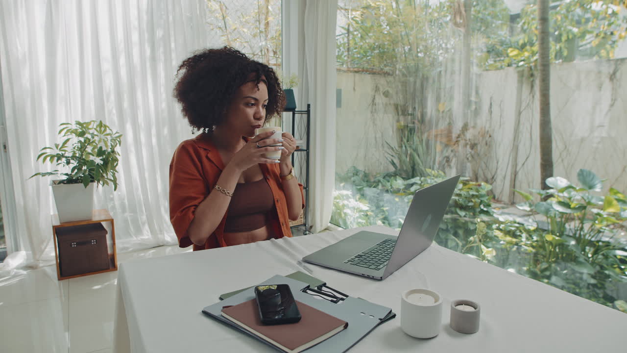Female Teleworker Preparing Tea while Doing Report from Home