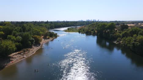 Eine-Ausgezeichnete-Luftaufnahme-Von-Menschen,-Die-Auf-Dem-American-River-In-Sacramento,-Kalifornien,-In-Wasserfahrzeuge-Einsteigen