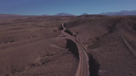 drone flight over winding road in the atacama desert with arid landscape in northern chile, south america