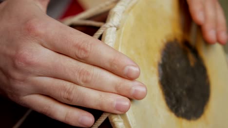 close up of hands of a man playing a drum.