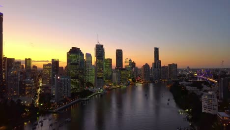 fast moving aerial view of a city riverside at sunset