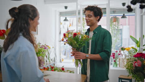 emotional shopper give flower present gift to beautiful florist woman in store.