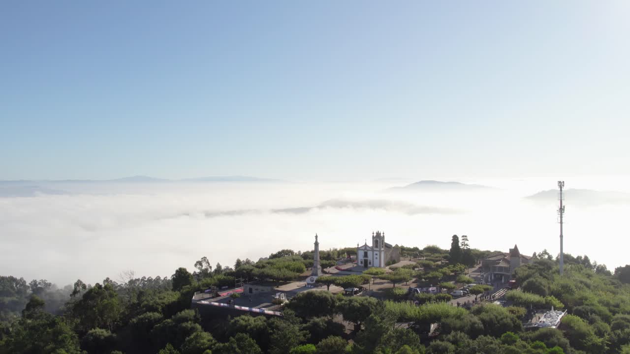 Fog surrounds Monte Franqueira's church and monument, with distant hills visible. Barcelos, Portugal