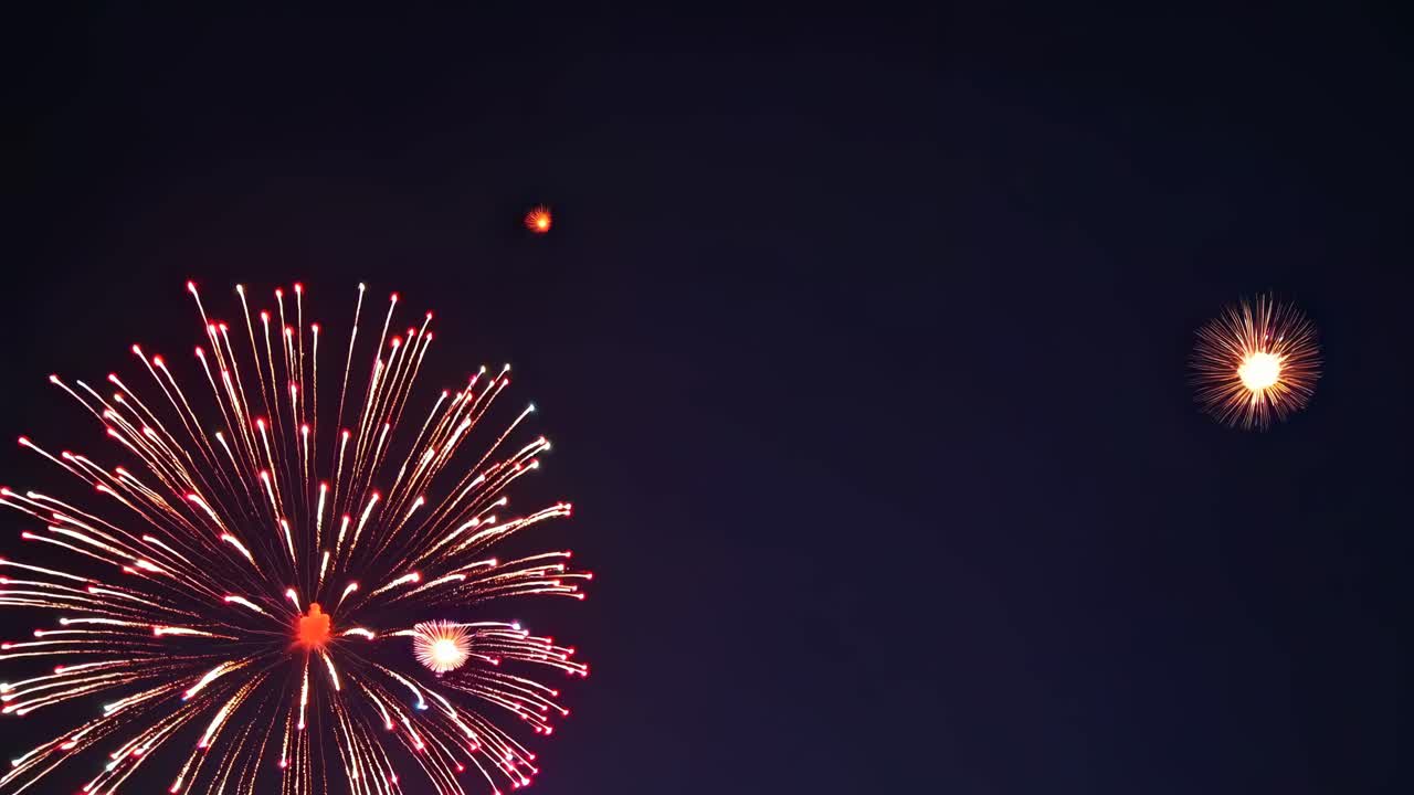A wide-angle video captures vibrant fireworks bursting against a dark sky, showcasing a festive