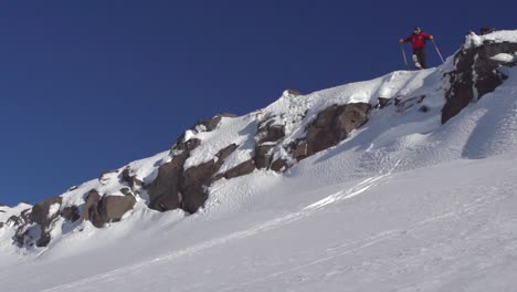 extreme freeriding skier jumping off cliff performing a grab trick in air, slow