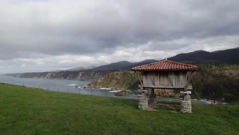 aerial shot of a horreo, traditional granary from the north of spain in a cliff next to the sea in the village of cadavedo. asturias