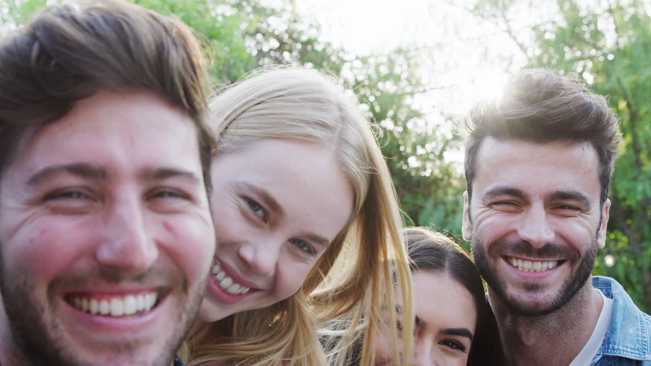 портрет группы друзей из разных культур, наслаждающихся летней вечеринкой в саду на открытом воздухе