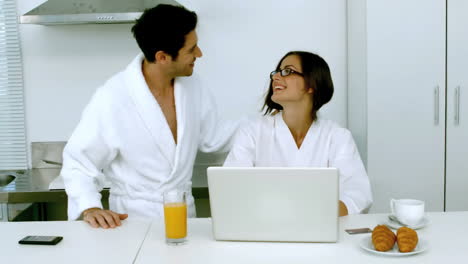 Man-kissing-his-girlfriend-while-she-is-having-a-breakfast