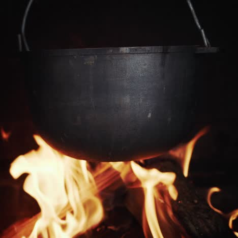 Gusseiserner-Topf-Hängt-In-Einem-Holzofen,-Der-Auf-Offenem-Feuer-Kocht