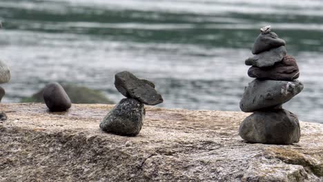 close up of cairns stacked on boulder on ocean beach