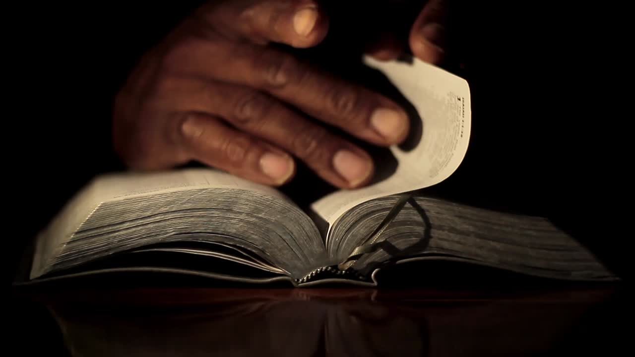 Prière à Dieu, la main sur la bible, fond noir avec des personnes, séquence d'archives.