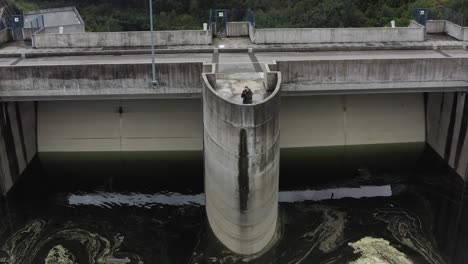 aerial: tourist photographer capturing photos at ribeiradio dam, sever do vouga, portugal