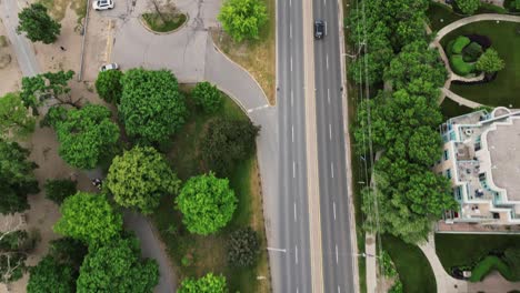 Conducción-De-Automóviles-En-Una-Carretera-Asfaltada-A-Través-De-Un-Barrio-Suburbano-Durante-El-Día