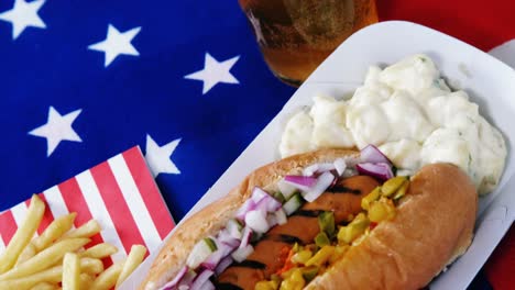 Hot-dog,-french-fries-and-glass-of-beer-served-on-American-flag