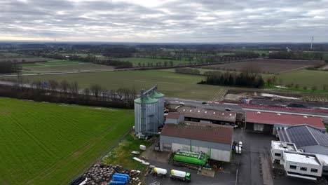 silo-lager der landwirtschaftlichen fabrik in der deutschen stadt. verkehr auf der autobahn und kreuzung in deutschland. ländliche landschaft. weitbild.