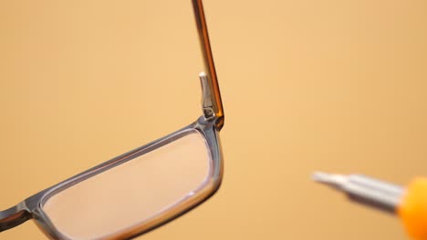 repairing eyeglasses with a small screwdriver