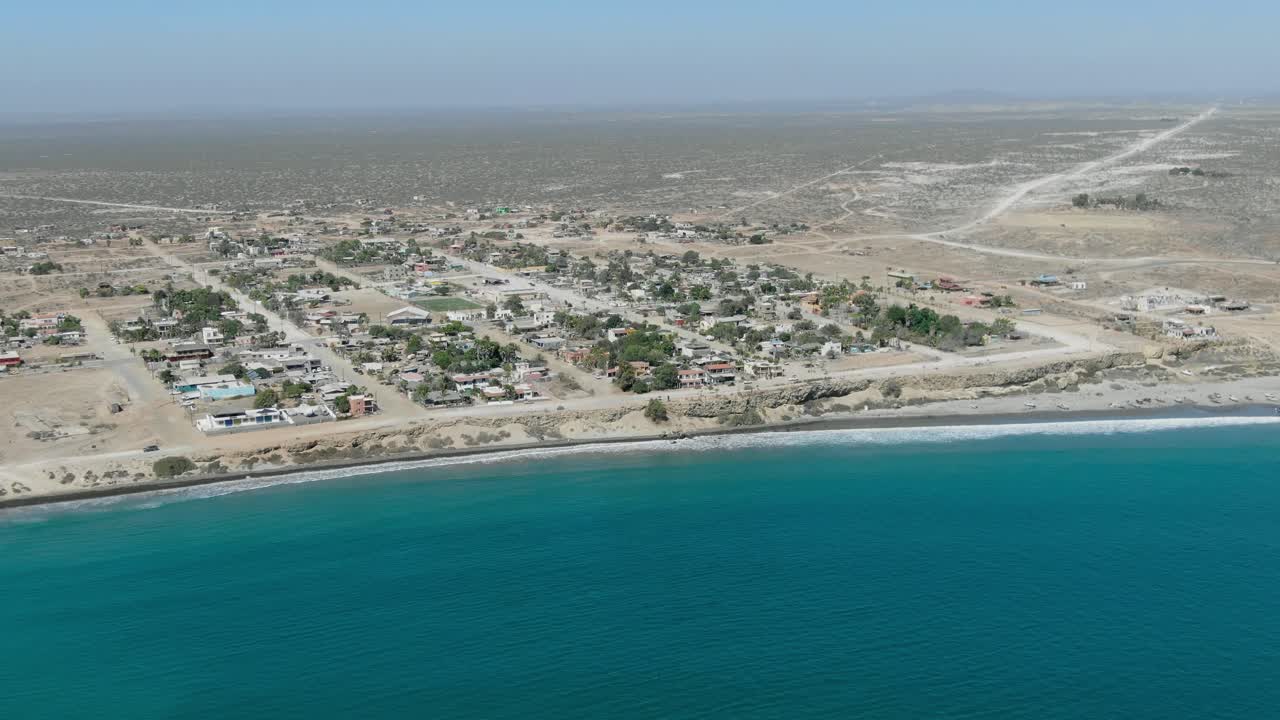 toma descendente de vista aérea, vista panorámica de la ciudad de san juanico en california sur, méxico, autos moviéndose a lo largo de la carretera cerca de la costa en un día soleado
