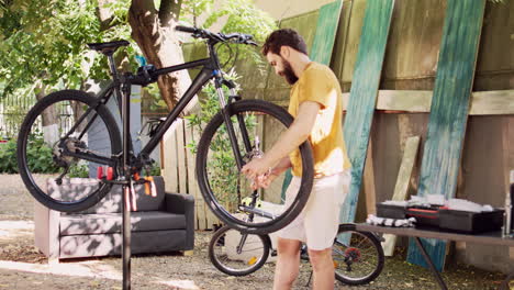 male dismantling damaged bicycle wheel