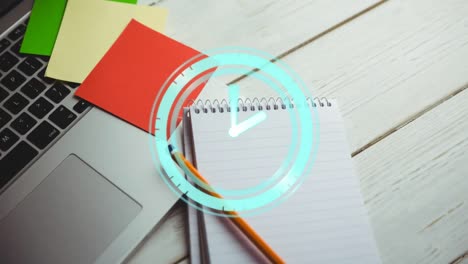 Animation-of-clock-ticking-over-notebook-and-laptop-on-wooden-table