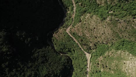 Forward-aerial-view-of-a-suggestive-road-in-the-middle-of-a-rock-face