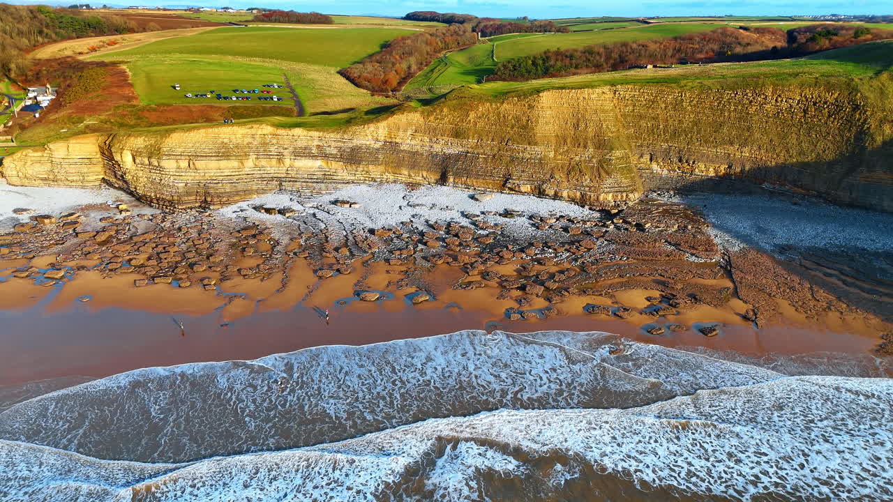 Vista dall'alto di costa rocciosa e strati di scogliera calcarea. Prospettiva aerea dall'alto delle formazioni geologiche e della spiaggia rocciosa a Southerndown, Galles del Sud.