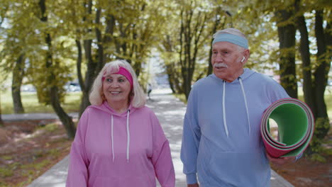 old grandparents walking with sport mat to do fitness exercises, training stretching cardio workout