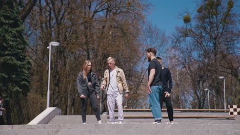 happy friends meeting in the park. group of young people having fun outdoors. guys enjoy their life together. friendship concept