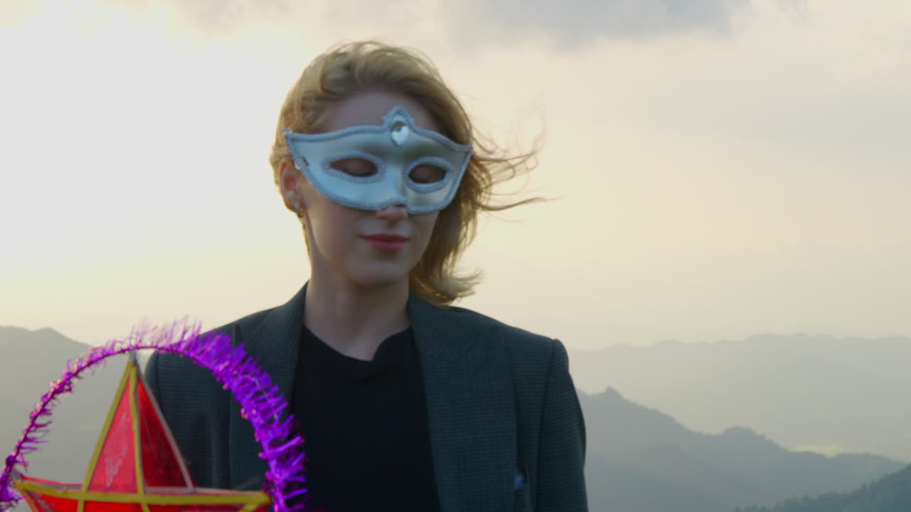 Woman in Mask with Star Lantern at Sunset in Mountains