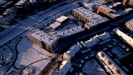 aerial approach of residential complex after a snowstorm with ettegerpark seen from above with rooftops full of solar panels covered in snow white in urban development real estate investment project