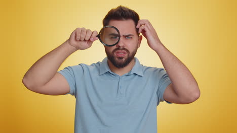 Investigator-researcher-man-with-magnifying-glass-near-face,-looking-into-camera-with-big-zoom-eye