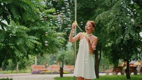 woman blowing bubbles in a park