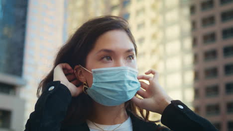 woman using medical mask outdoors closeup. asian girl care health in pandemic.