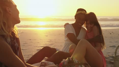 amigos adultos jóvenes relajándose en la playa al atardecer 4k