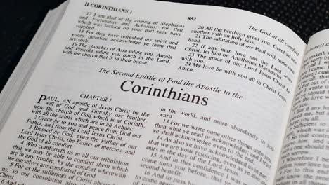 primer plano de la página de la biblia pasando al libro de segundo corintios