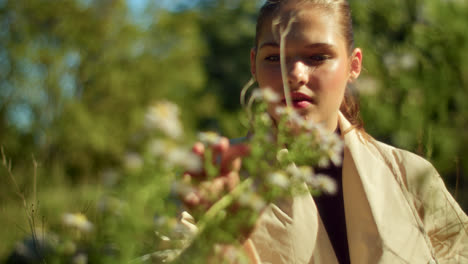 young woman enjoying flowers in a field