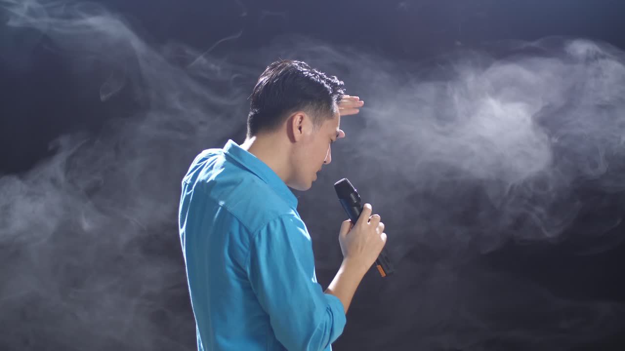 hombre cantando en el micrófono en el escenario