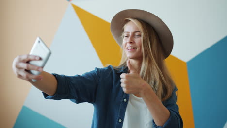 woman taking a selfie with a thumbs up