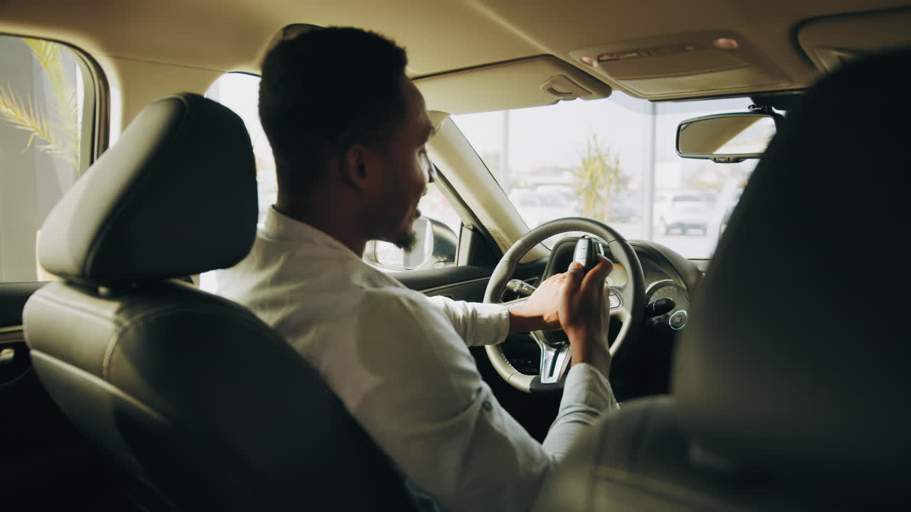 hombre conduciendo un coche en una sala de exposiciones