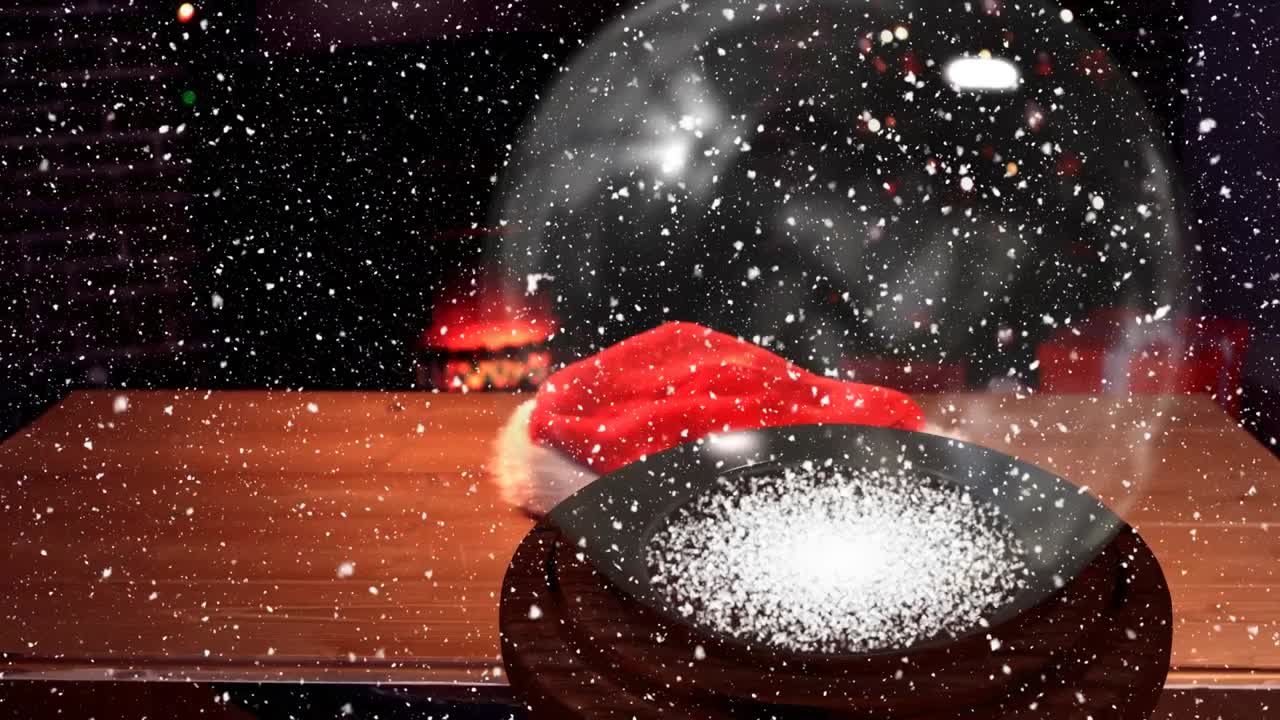 Animation of glass ball over snow falling and santa hat