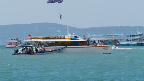 Fähren-Warten-Auf-Passagiere,-Die-Vor-Dem-Strand-Von-Pattaya-In-Der-Provinz-Chonburi-In-Thailand-Ihre-Parasiling-Aktivität-Ausüben