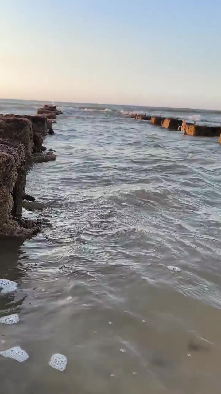 Dolci onde oceaniche che si infrangono su una costa rocciosa al tramonto