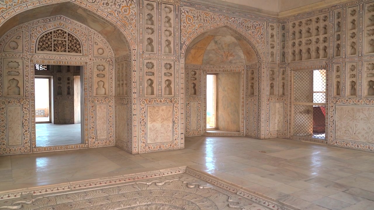 Inquadratura in tilt up da una fontana in marmo intagliato a forma di loto alle pareti ornate in pietra dura all'interno del Musamman Burj presso il Forte di Agra in Uttar Pradesh, India