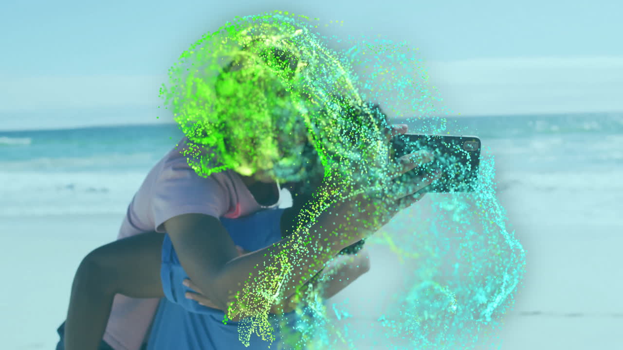 woman leaning on man snapping smartphone selfie on beach, featuring swirling tech particles