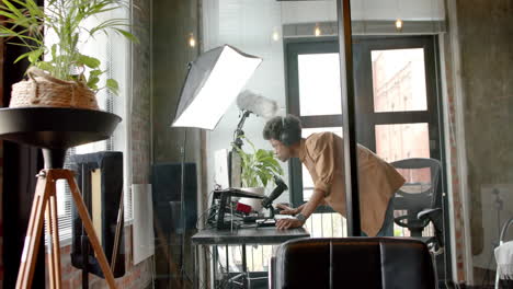 Happy-african-american-man-standing-at-desk-making-live-podcast-from-home,-copy-space,-slow-motion