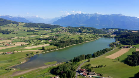 clear and blue stretch of bret lake in the swiss countryside with idyllic alpine landscape in background